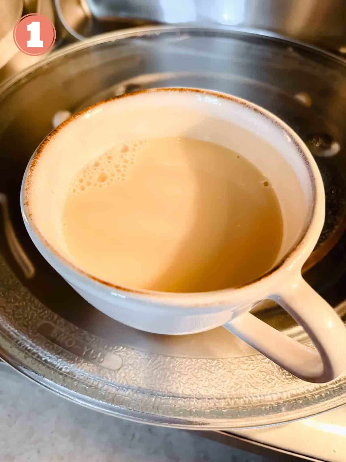 oat milk in a beige mug being heated in the microwave labelled number one.