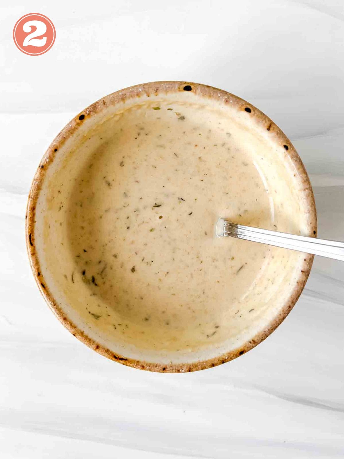 tahini dressing in a cream bowl with a spoon labelled number two.