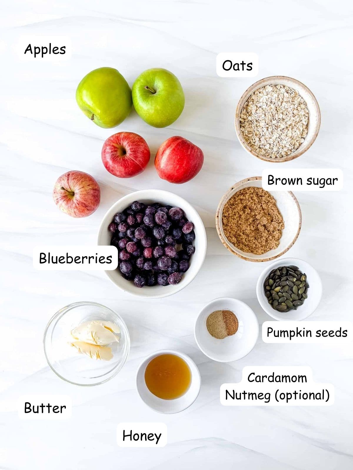 individually labelled ingredients to make apple crisp including green and red apples, oats, brown sugar, butter and honey.