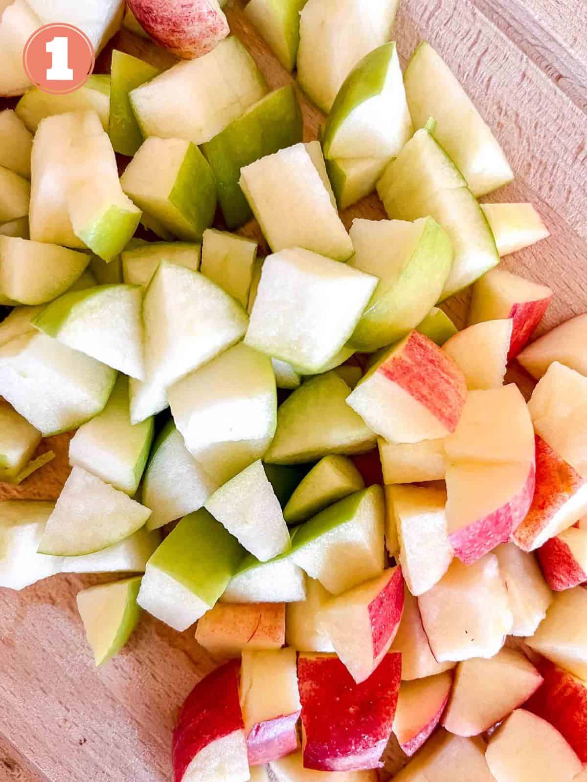 diced red apples and Granny Smith apples on a wooden chopping board labelled number one.