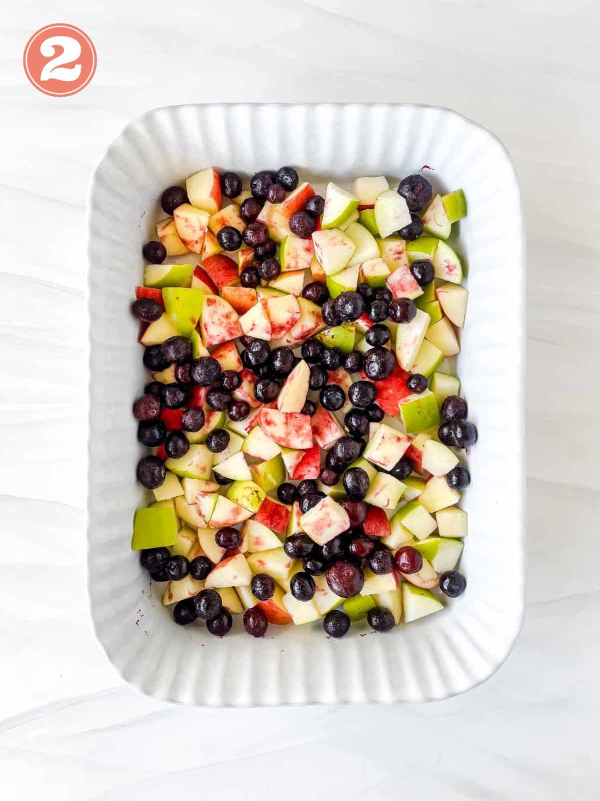 diced apples and blueberries in a baking pan labelled number two.
