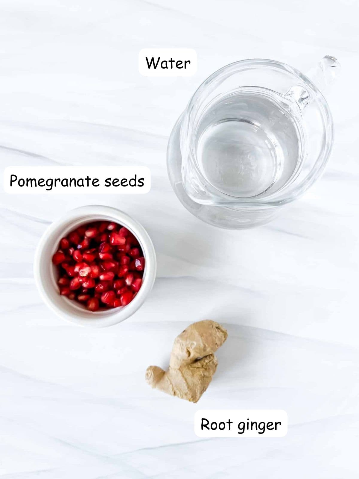 individually labelled ingredients to make pomegranate tea including water, root ginger and pomegranate seeds.