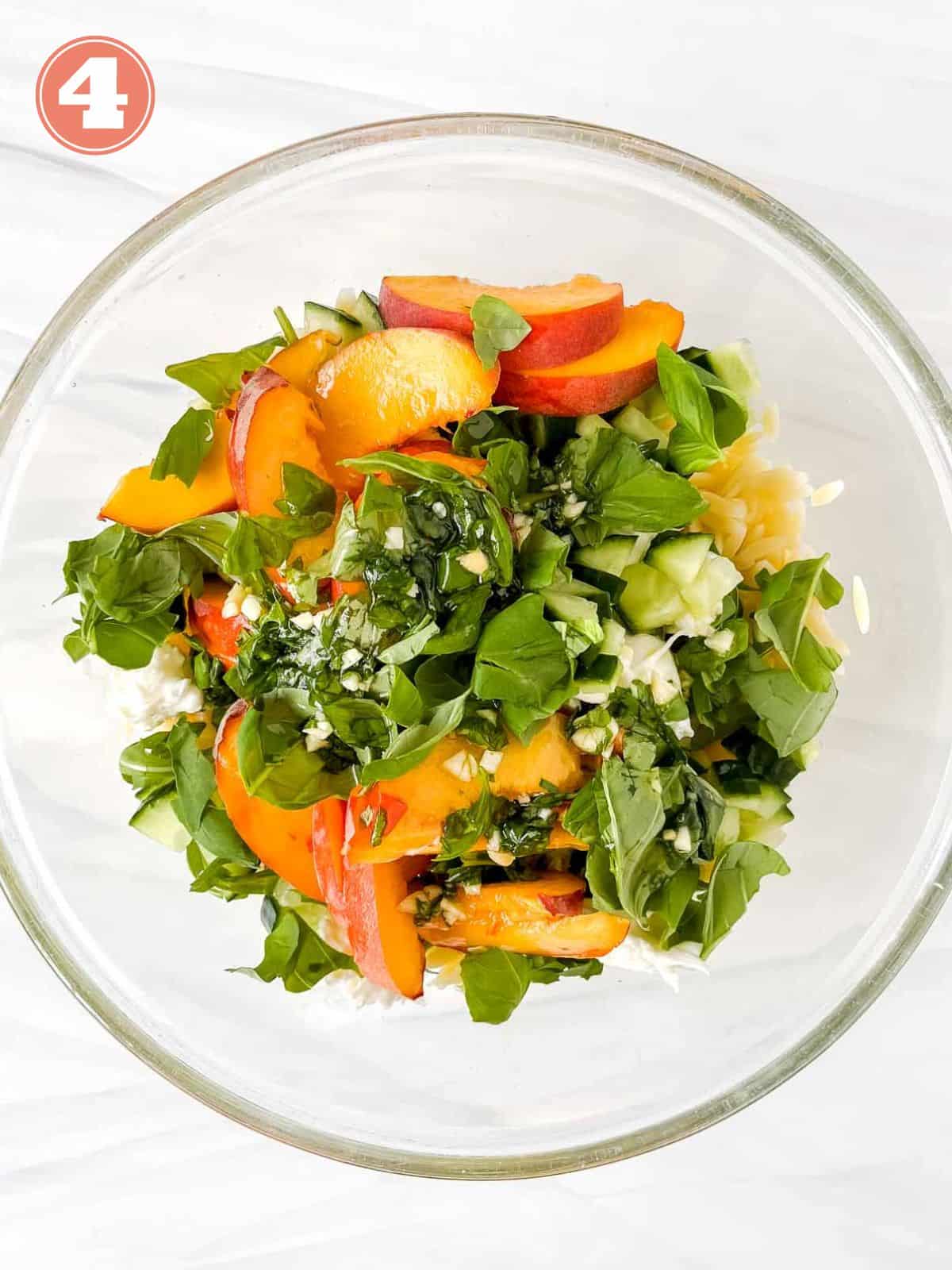sliced fresh peaches, basil leaves, arugula, orzo pasta and cucumber in a glass bowl labelled number four.