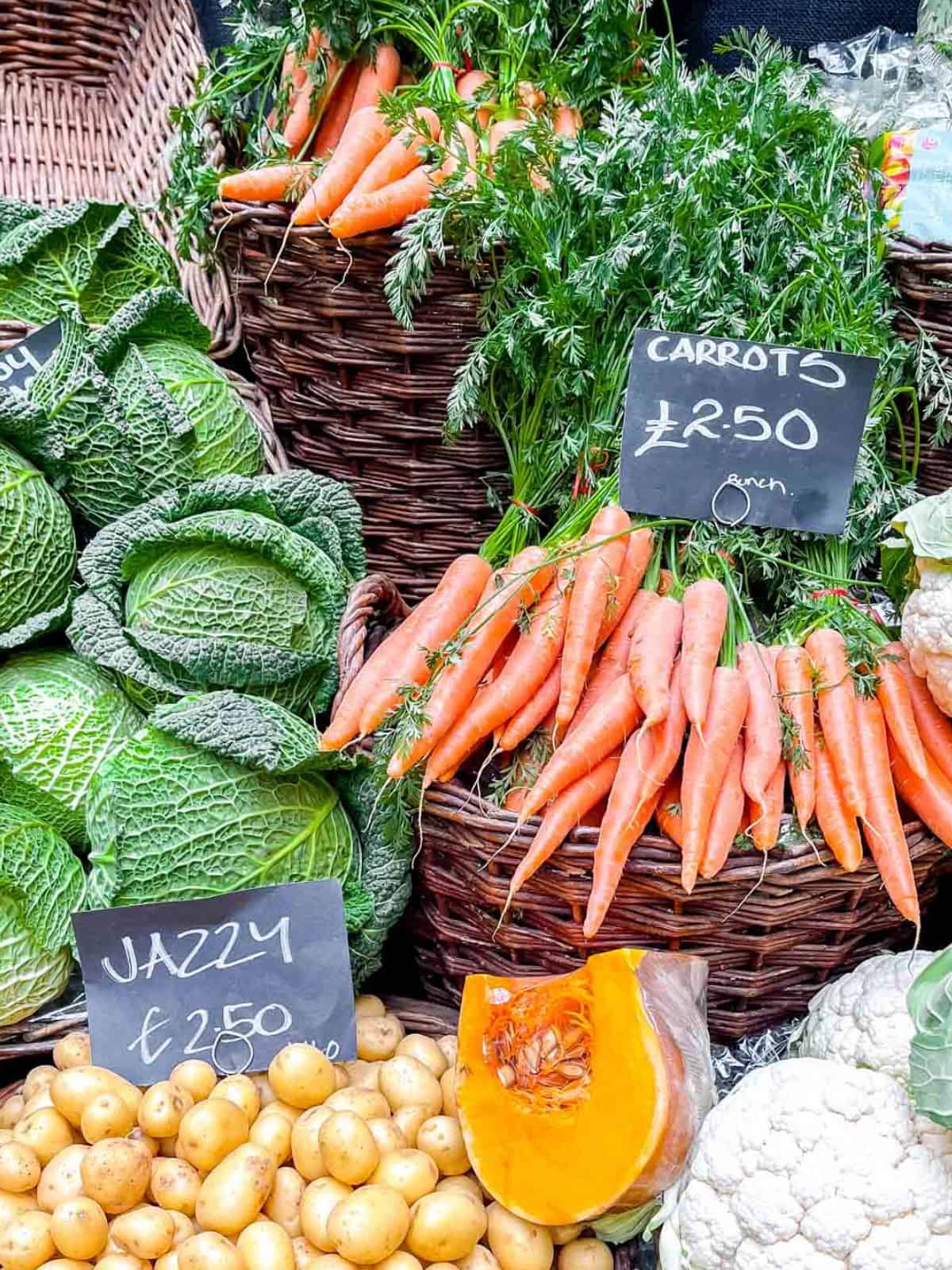 baskets of carrots, cabbages, potatoes and cauliflower.