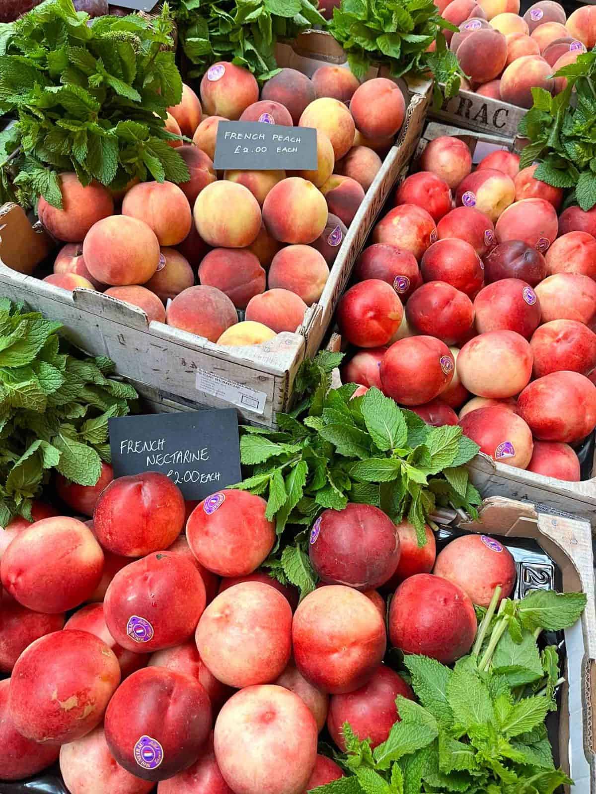 peaches and nectarines in wooden boxes next to fresh mint.