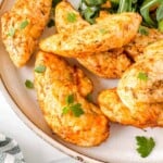 air fryer chicken mini fillets on a light brown plate garnished with fresh herbs.