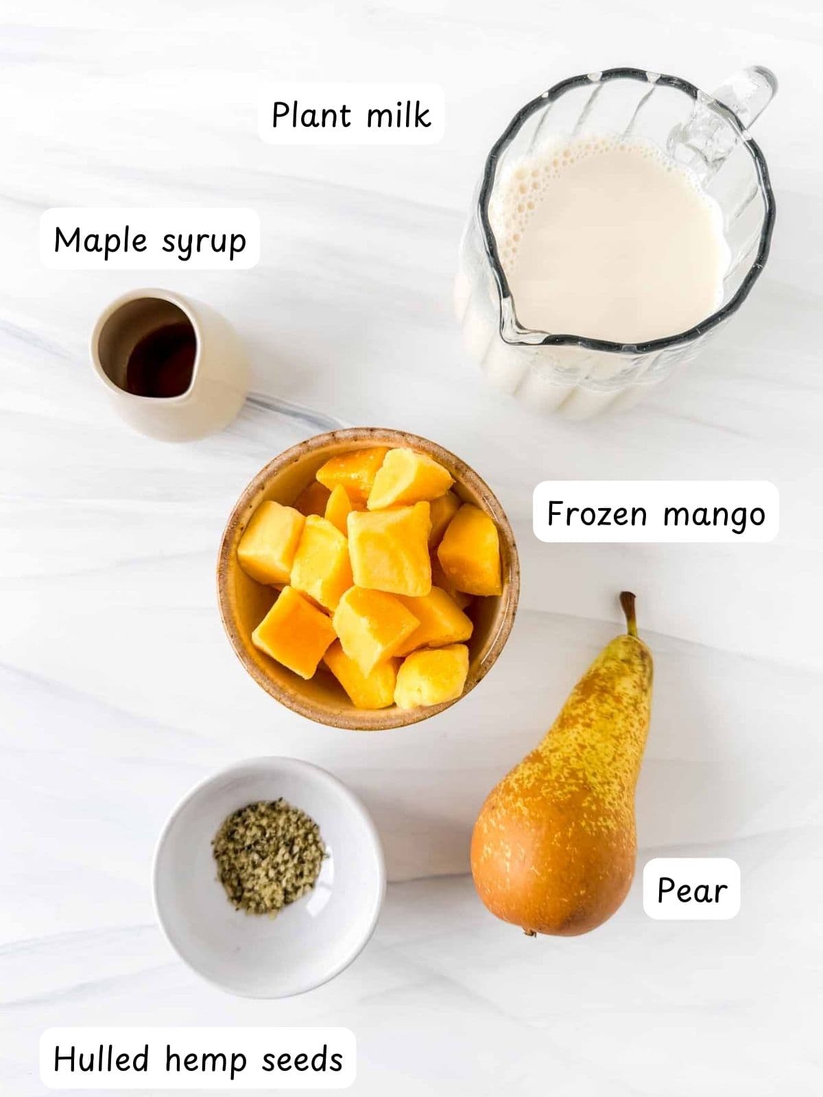 individually labelled frozen mango, plant milk, maple syrup, pear and hulled hemp seeds.