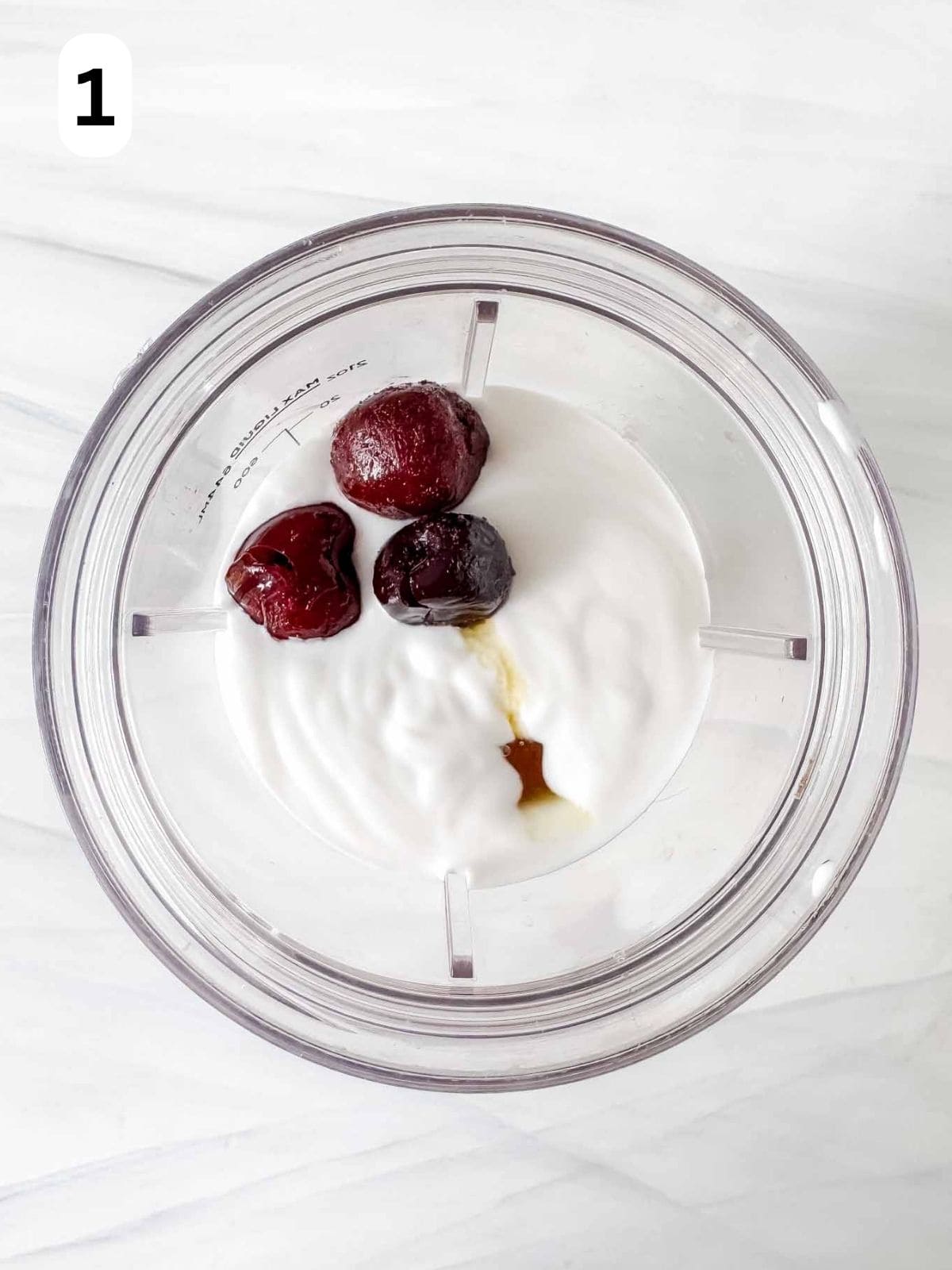 frozen cherries, coconut milk and maple syrup in a blender cup labelled number one.