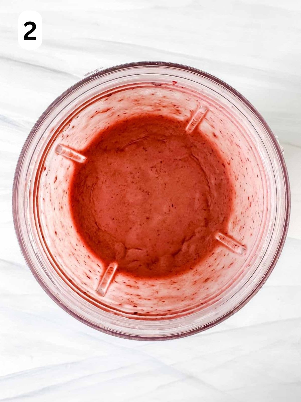 blended cherries and coconut milk in a blender cup labelled number two.