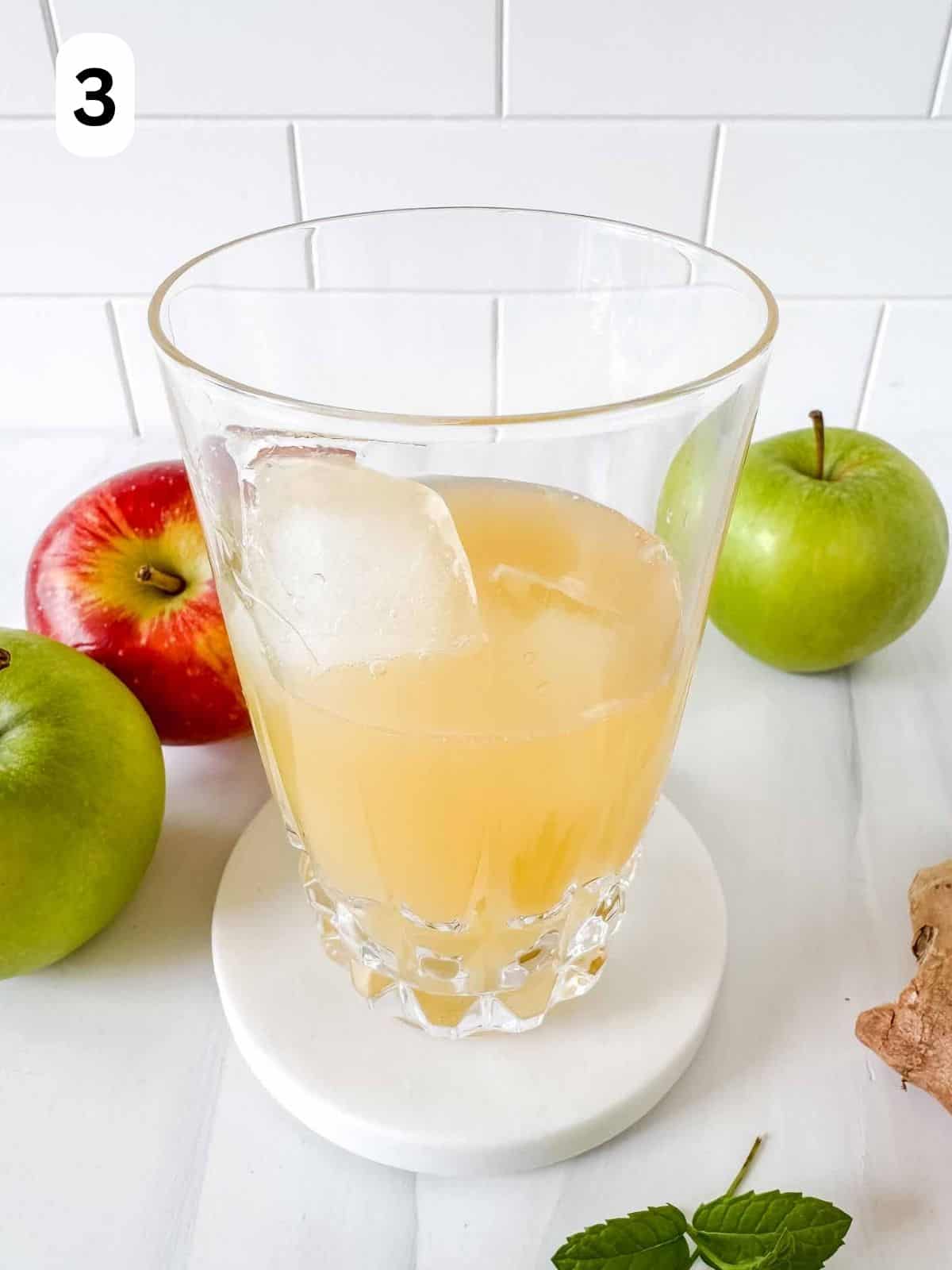 apple juice and ice cubes in a glass labelled number three.