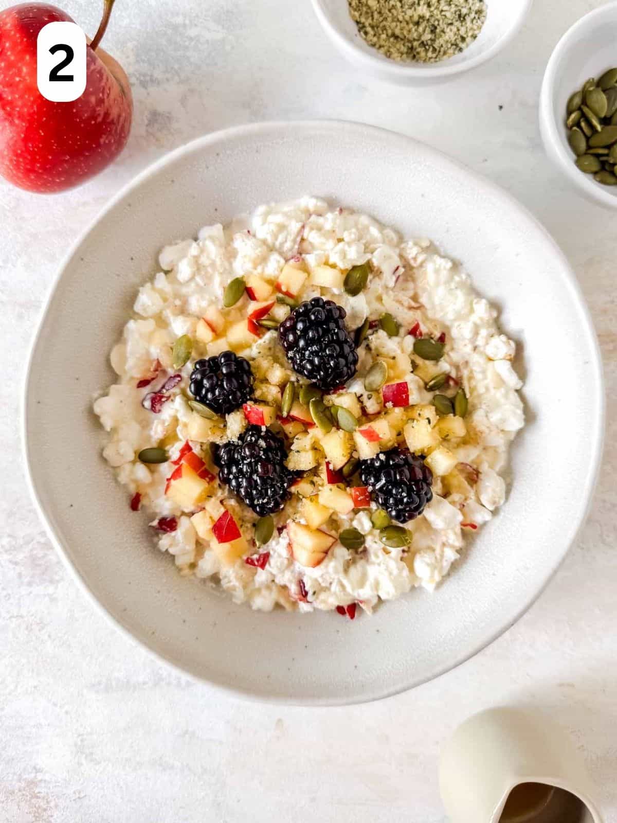 cottage cheese and apple bowl topped with fruit and seeds labelled number two.