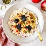 cottage cheese and apple bowl topped with diced apples, blackberries and seeds.