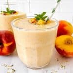 peach protein smoothie without yogurt in two glasses next to fresh peaches.