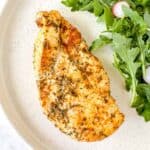 air fryer thin chicken breast on a plate with arugula.