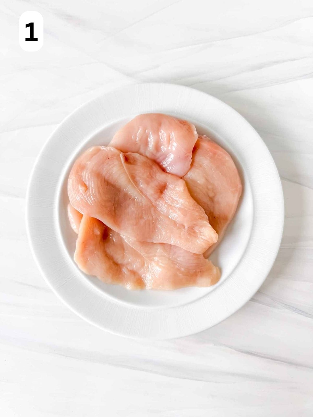 pieces of thin chicken breast on a white plate labelled number one.