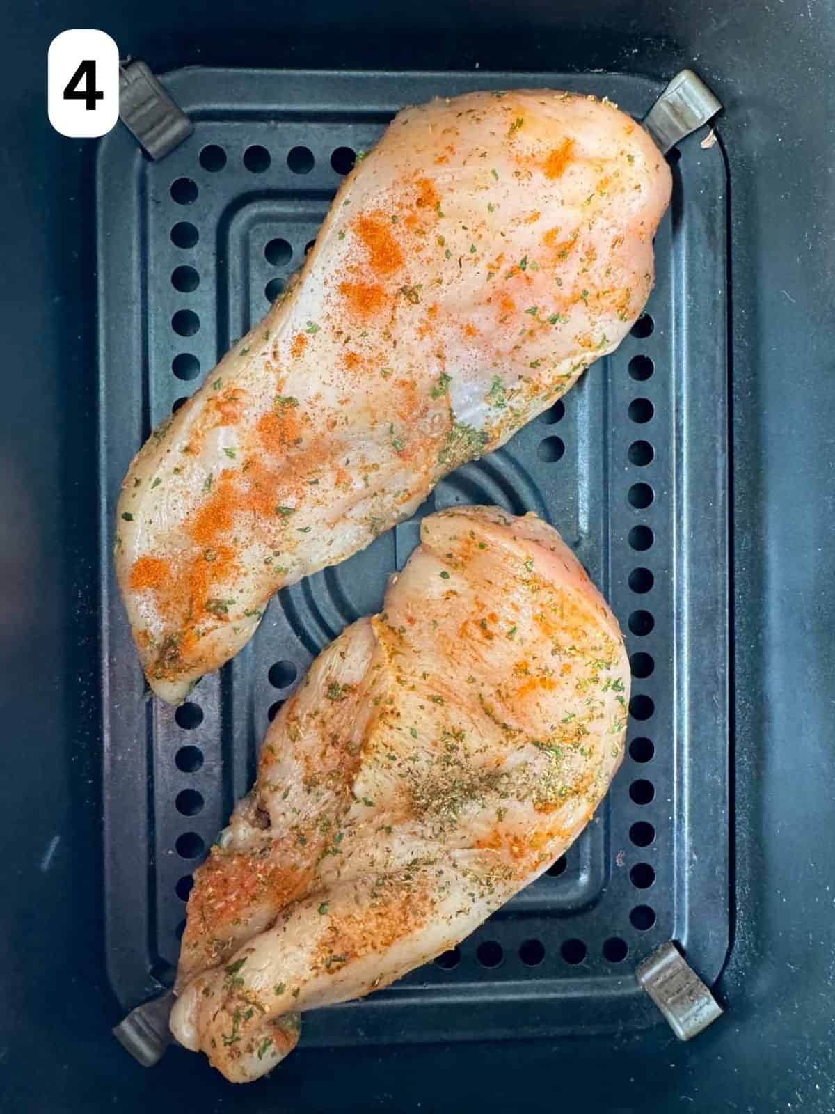 thin chicken breasts in an air fryer basket labelled number four.