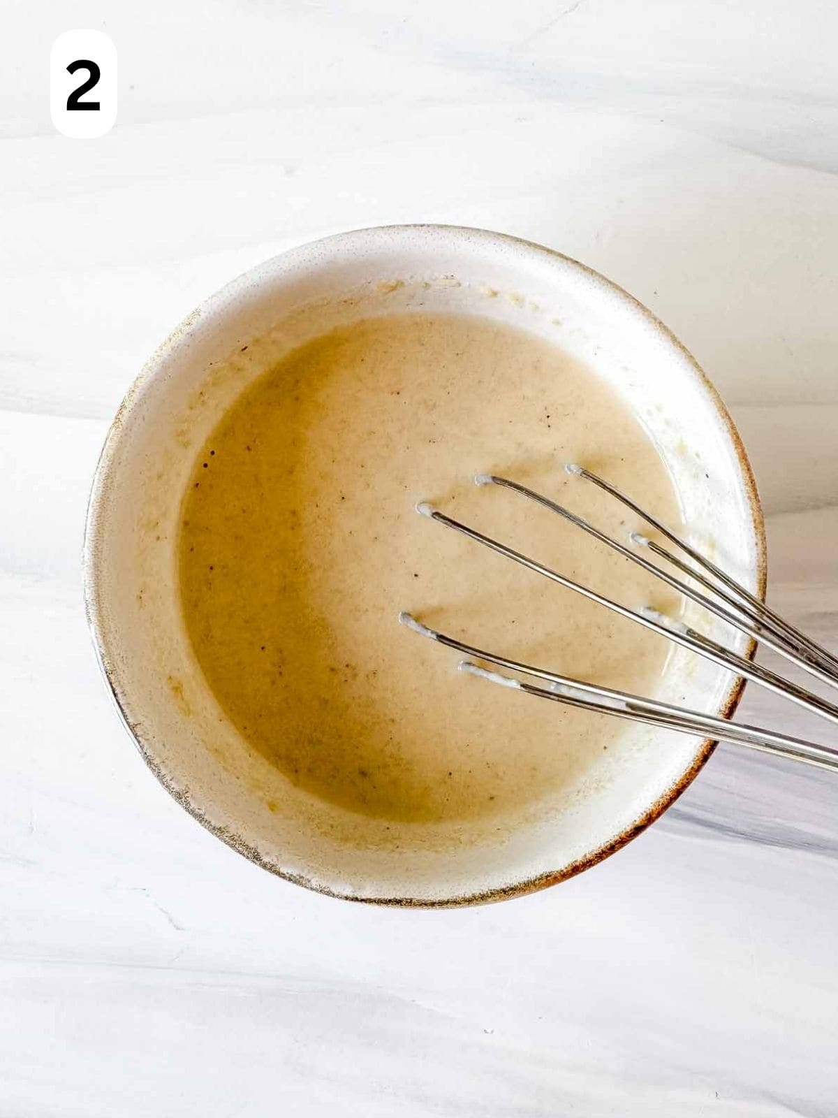 tahini dressing being whisked in a bowl labelled number two.
