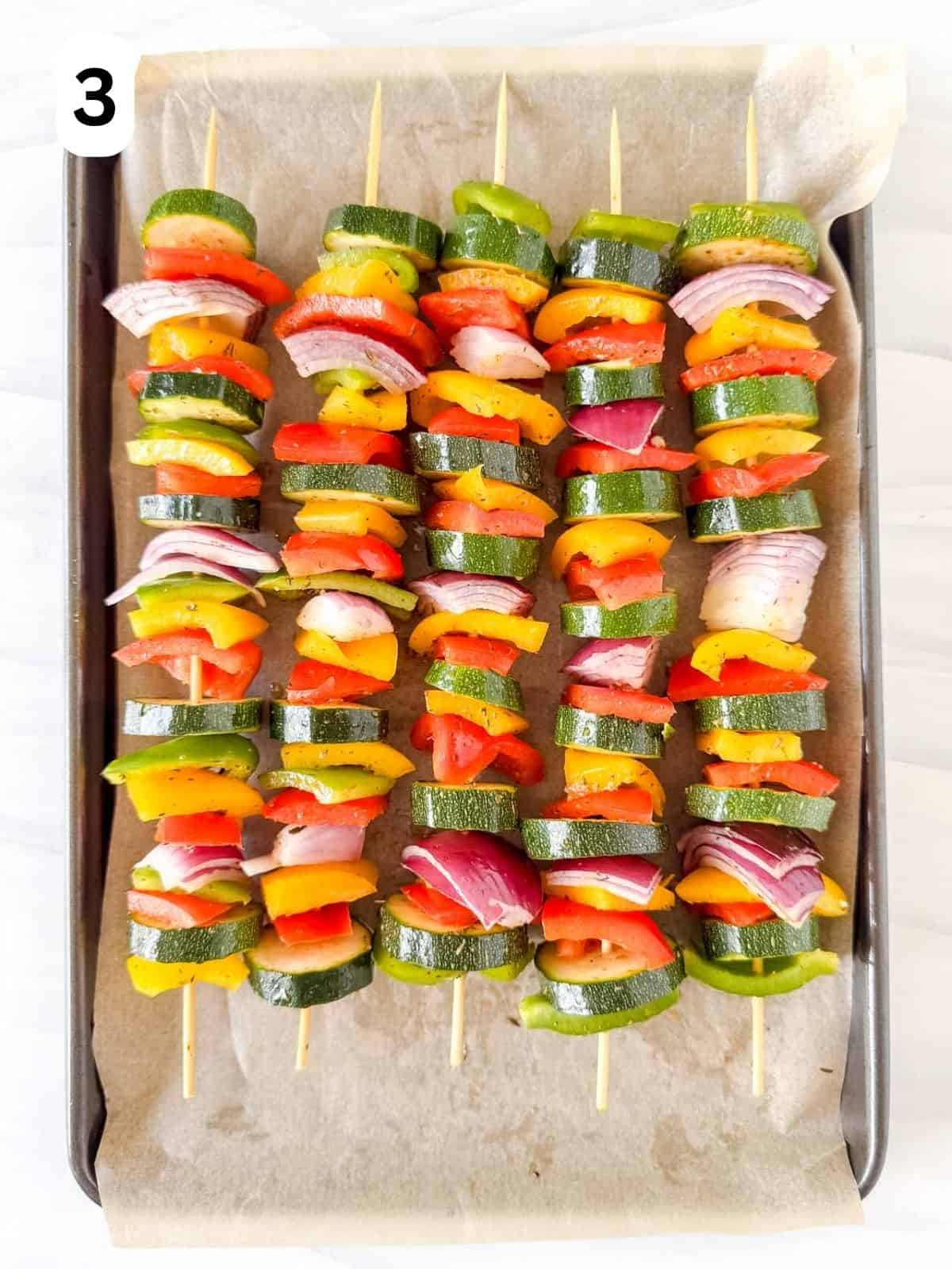 vegetable kabobs on a lined baking sheet labelled number three.