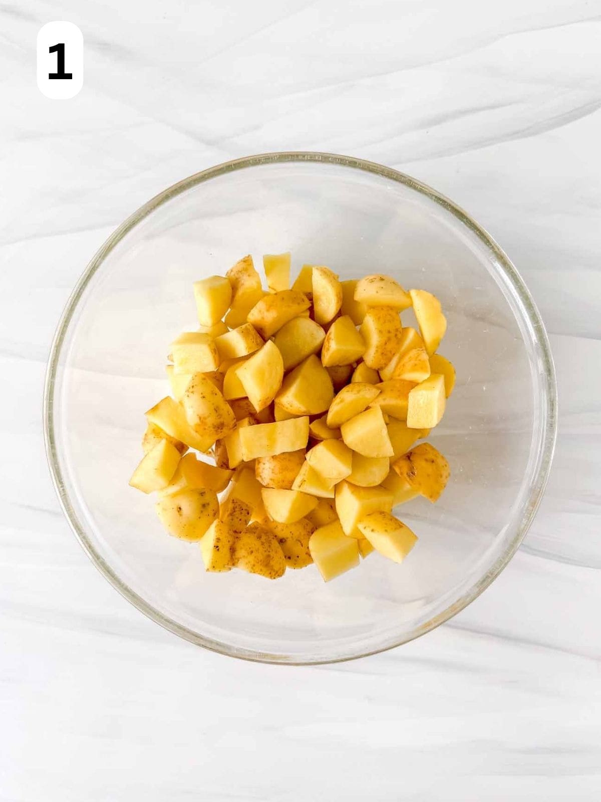 diced potatoes in a glass bowl labelled number one.
