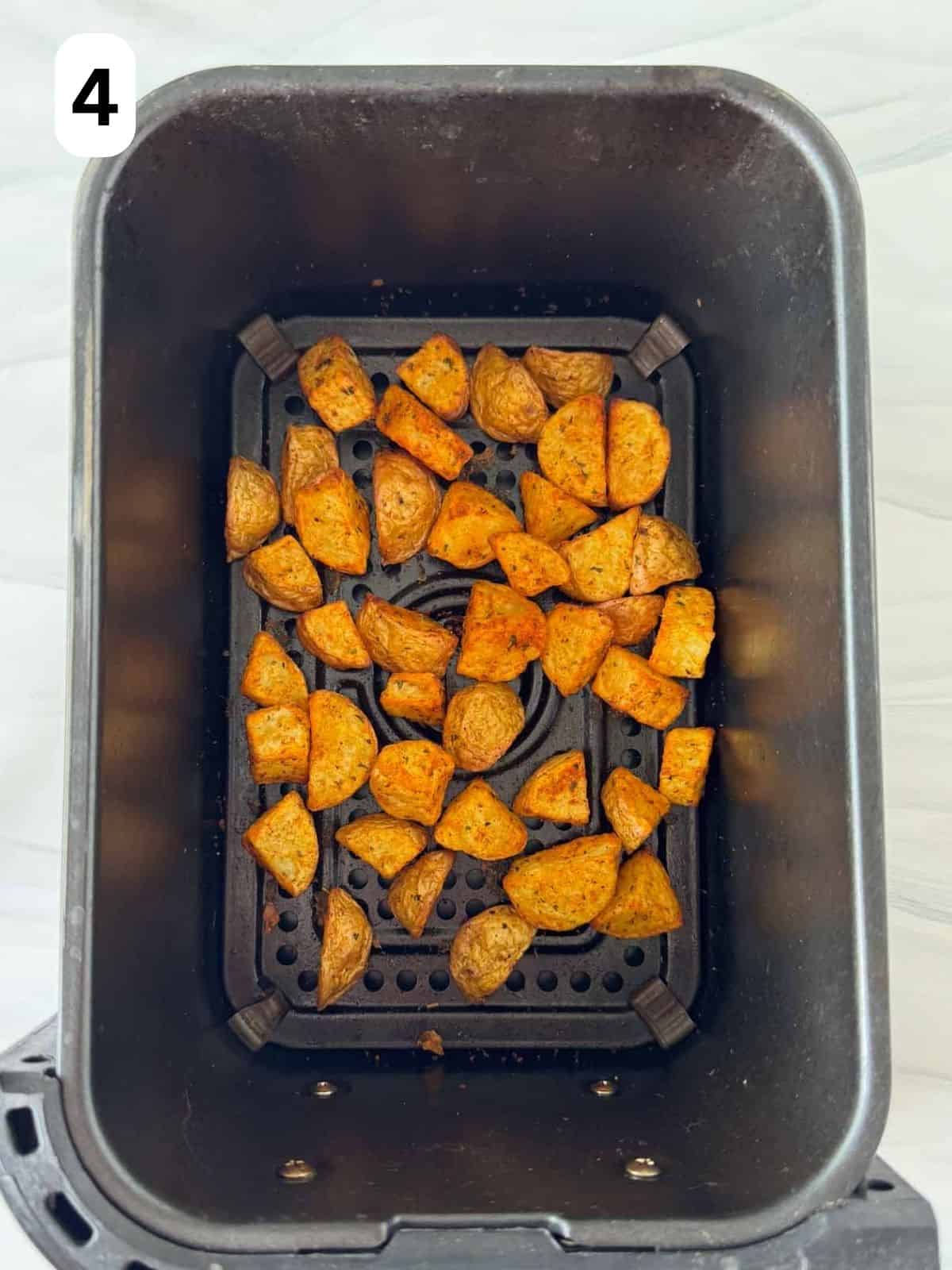 cooked diced potatoes in air fryer basket labelled number four.