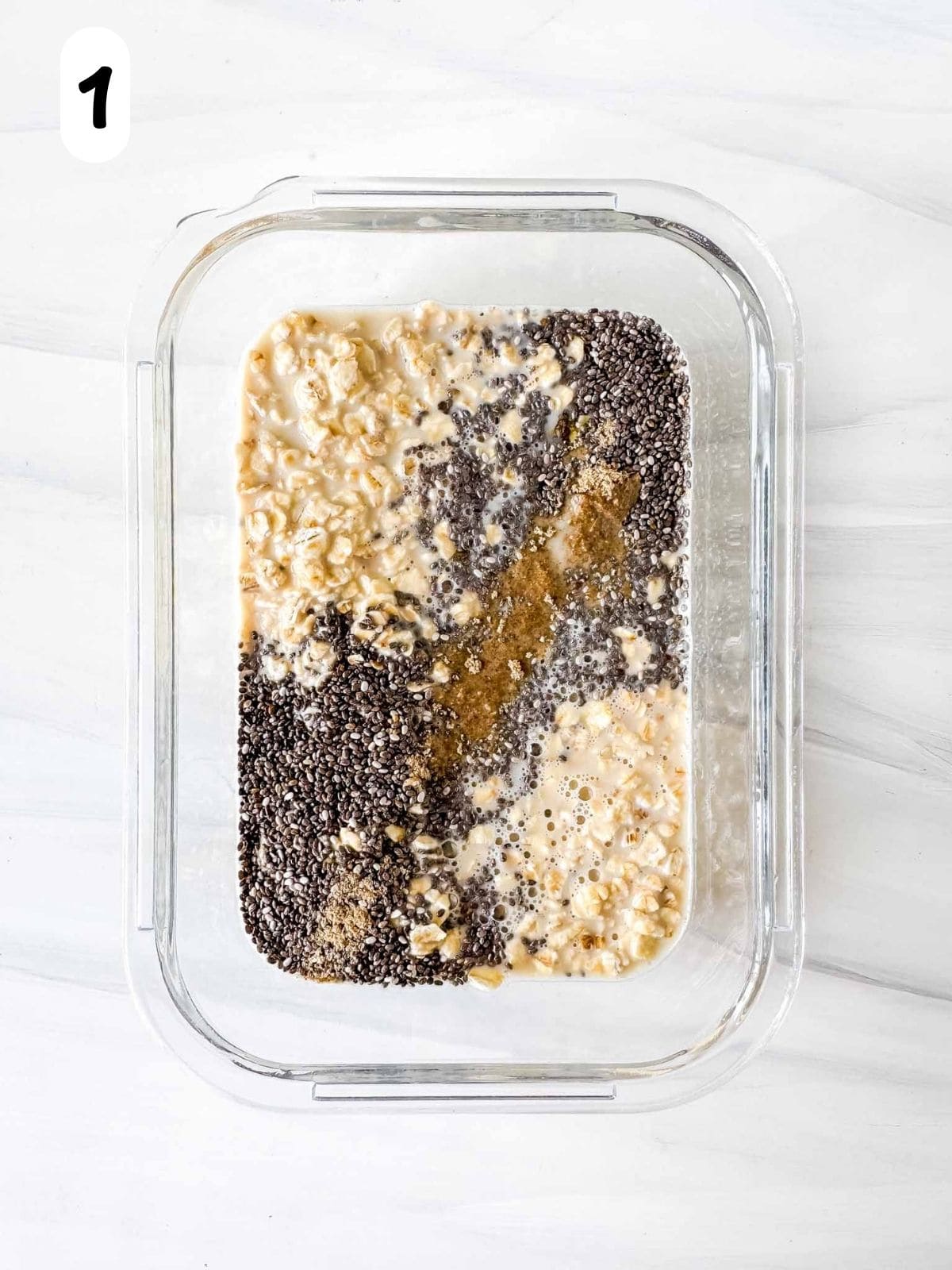 oatmeal, chia seeds, cardamom, maple syrup and milk in a glass container labelled number one.