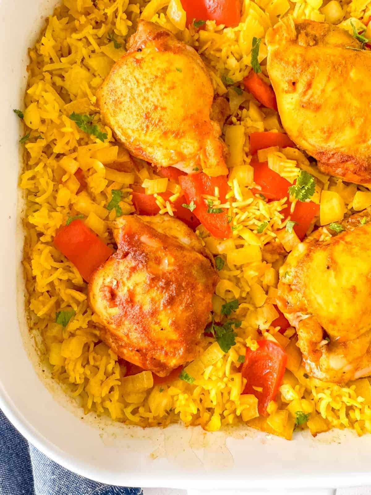 turmeric chicken and rice casserole in a white dish.