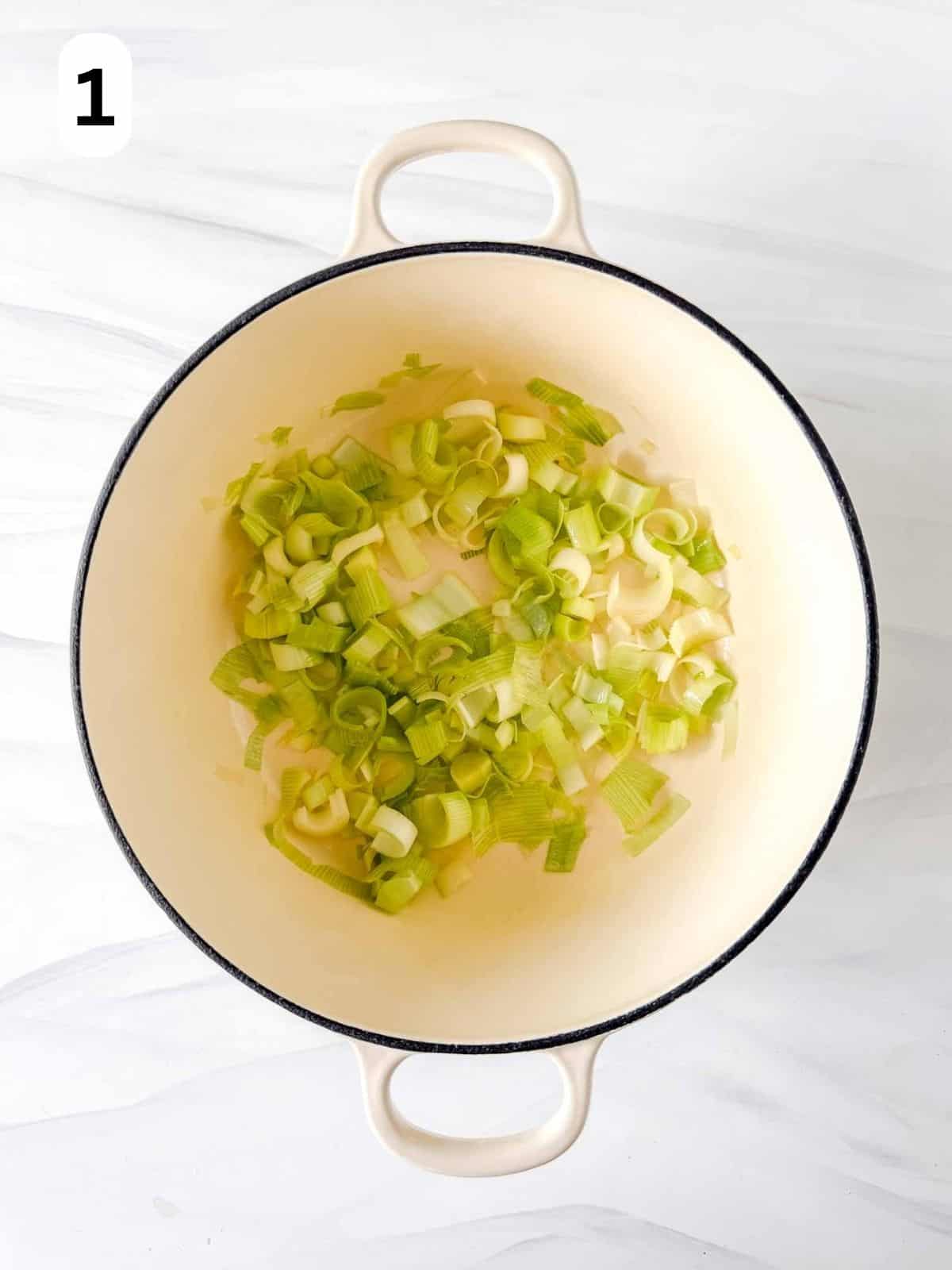cooked leeks in a white soup pot labelled number one.