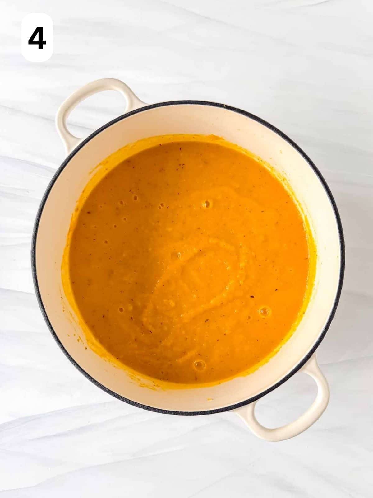 blended squash and carrot soup in a white soup pot labelled number four.