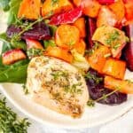 sheet pan chicken and sweet potatoes with beets, apple and lettuce on a white plate.