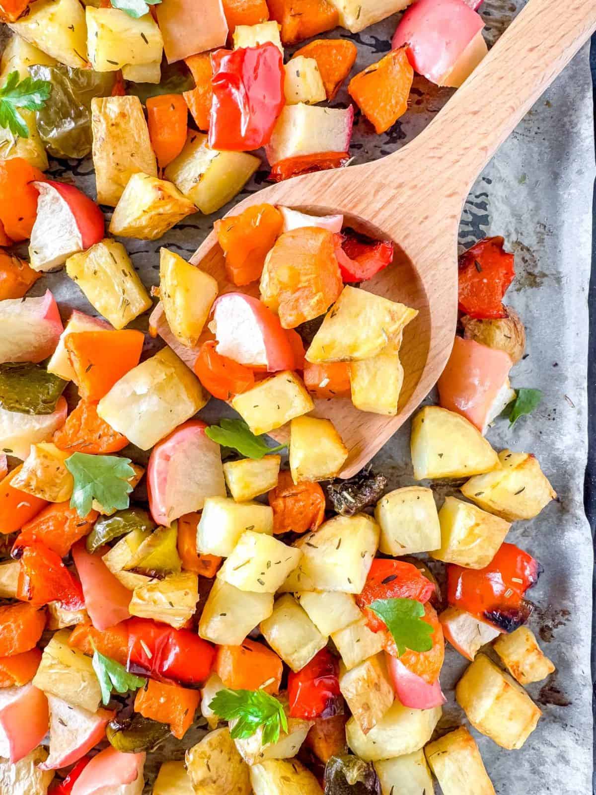 sweet potato and potato hash on a sheet pan with a spatula.