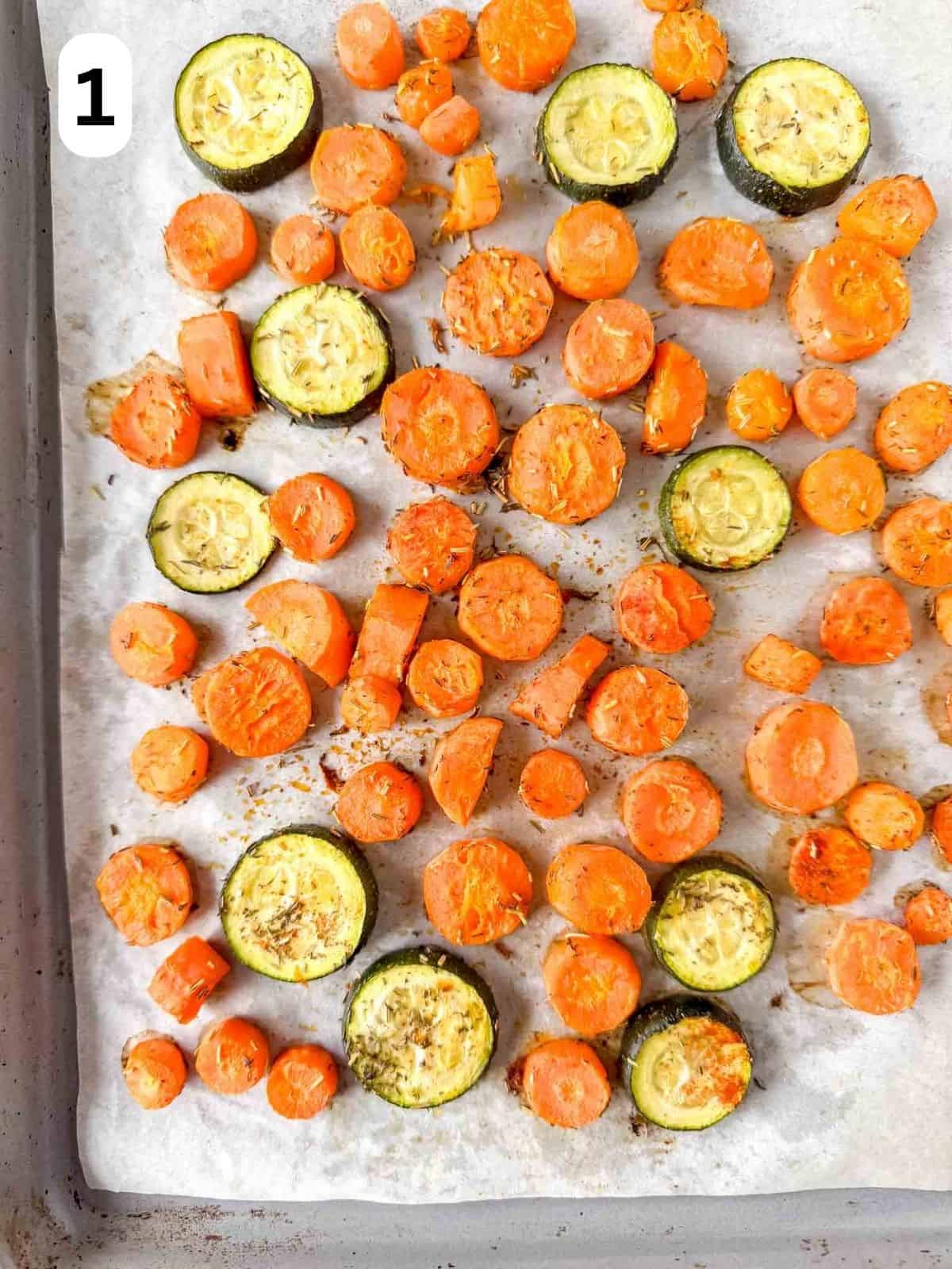 roasted carrots and zucchini rounds on a baking sheet labelled number one.
