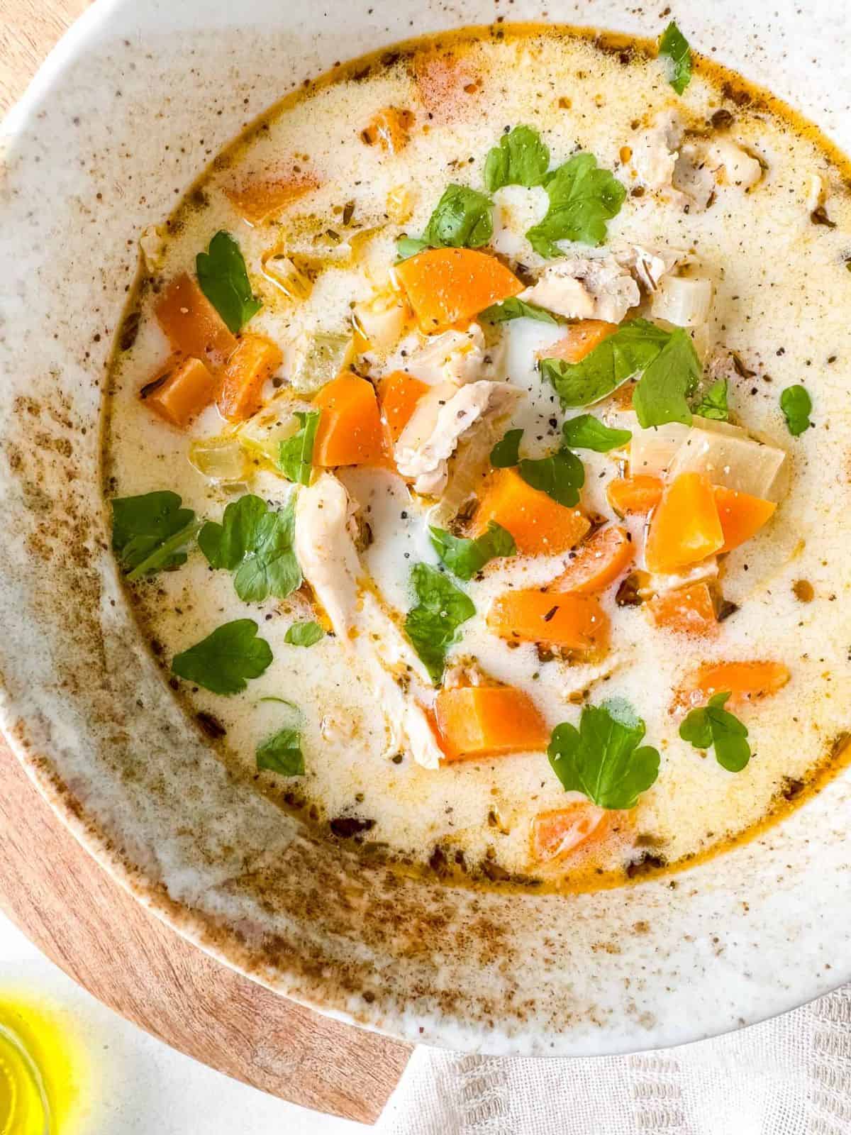 dairy free creamy chicken soup in a bowl garnished with fresh parsley.