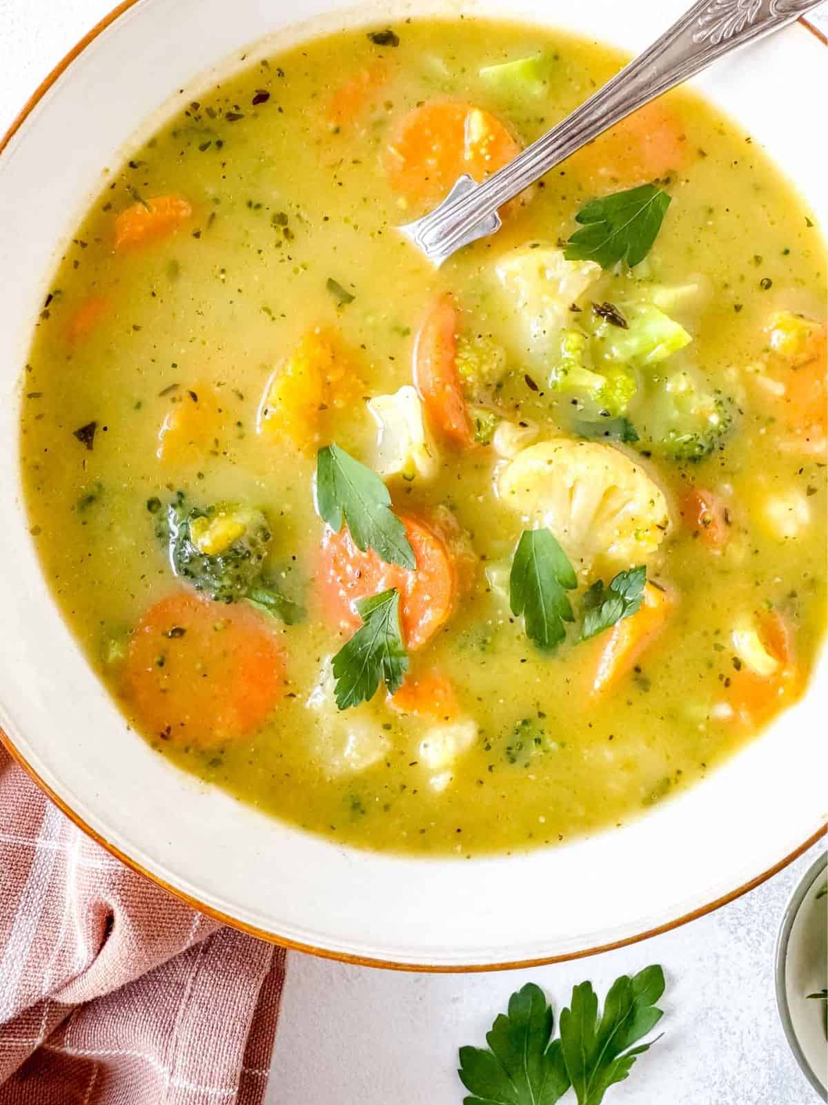 frozen vegetable soup in a white bowl with a spoon in it.