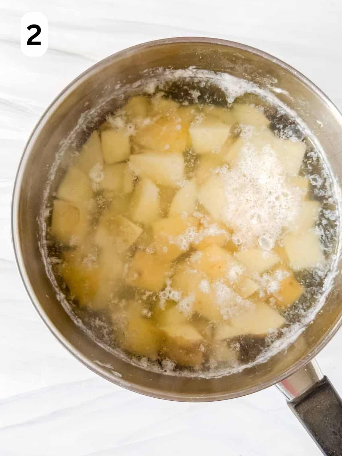 cubed russet potatoes in water in a large pot labelled number two.