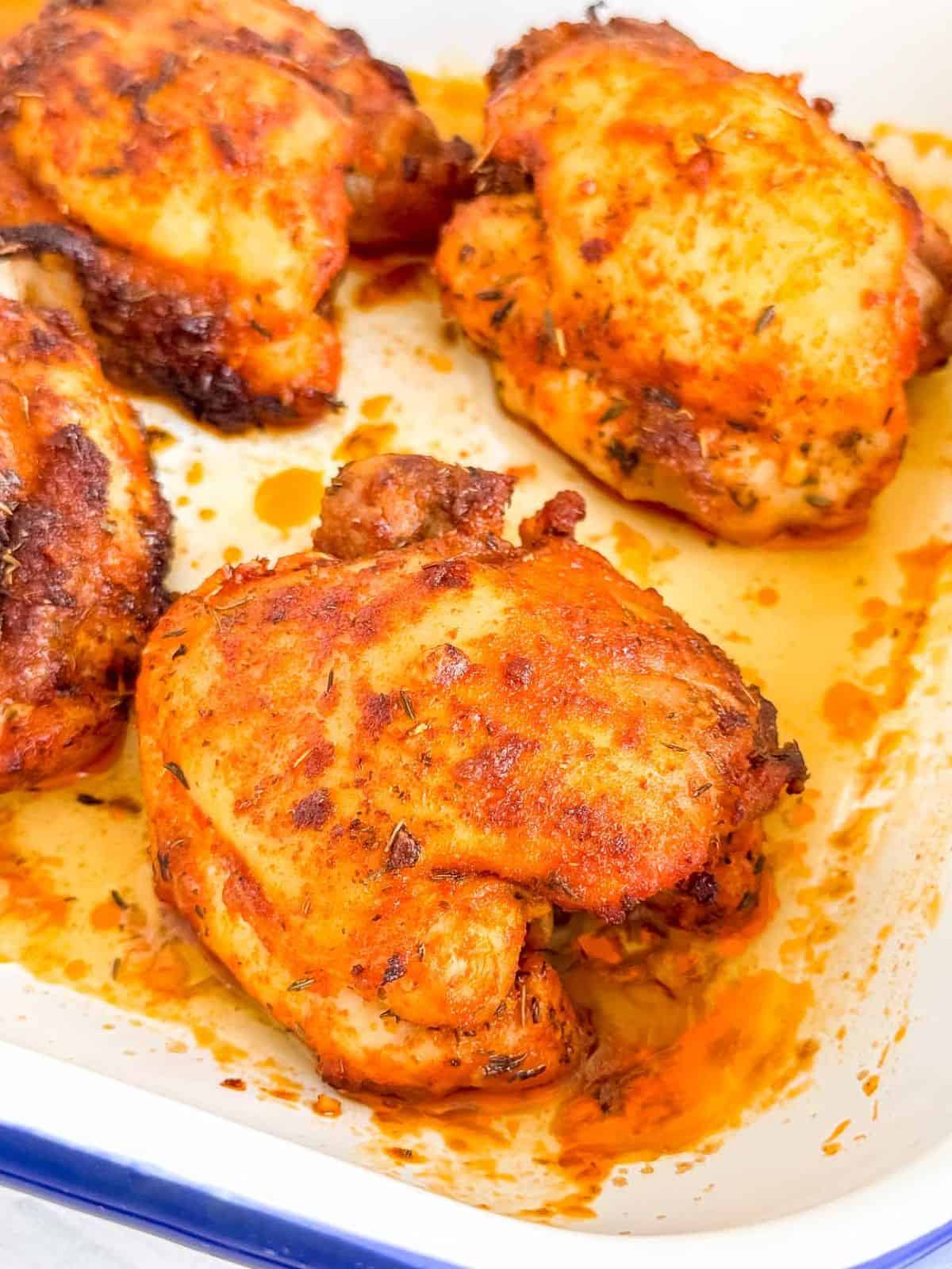 paprika baked chicken thighs in a baking dish.