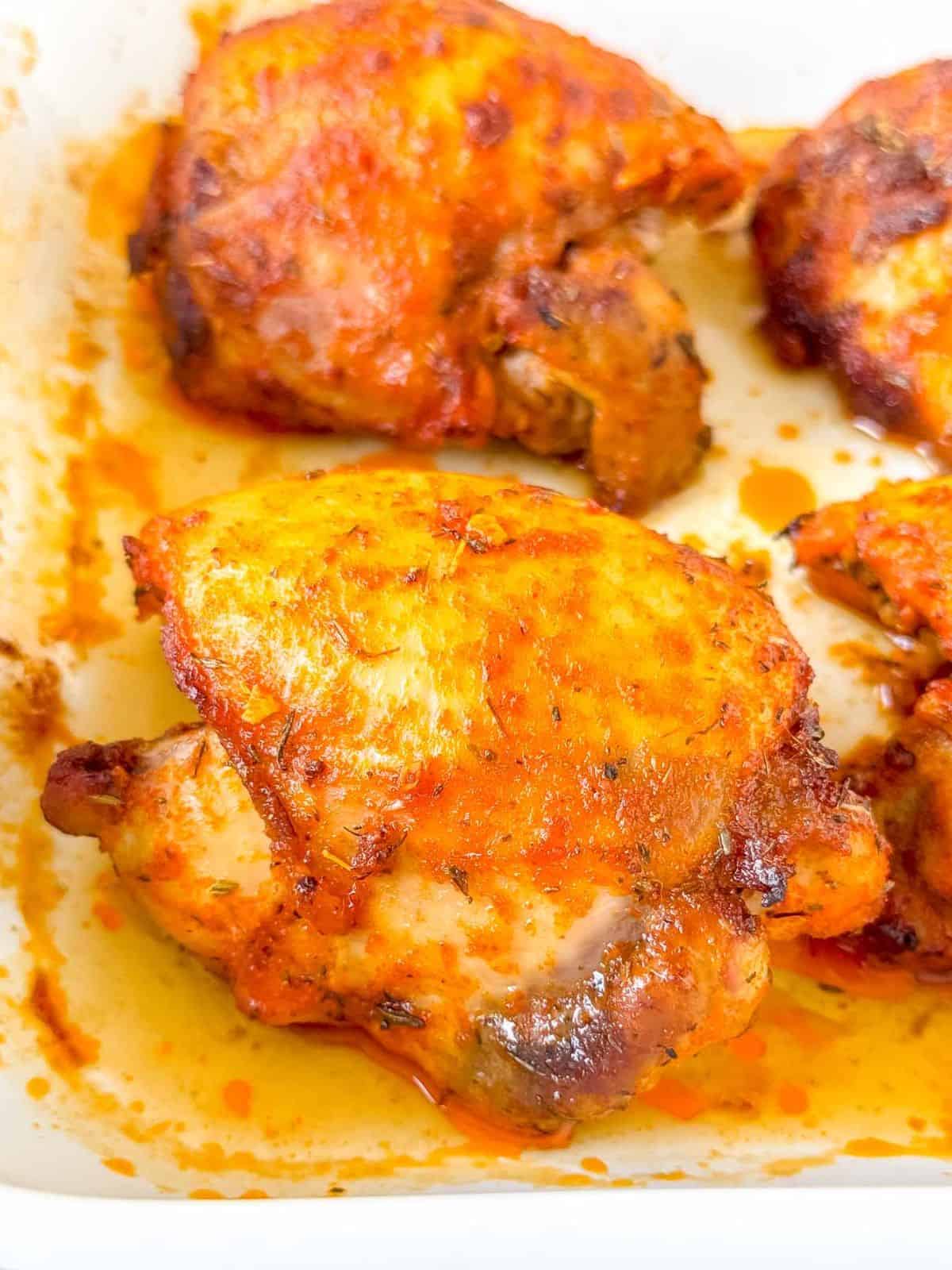paprika baked chicken thighs in a baking dish.