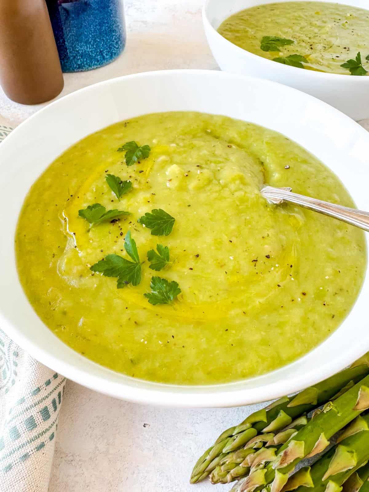 asparagus potato soup in two white bowls.