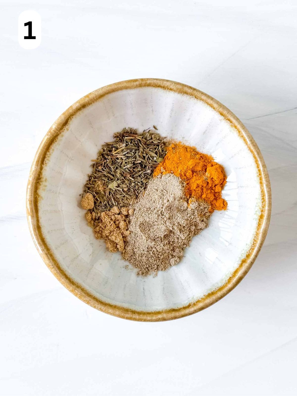 small bowl with cardamom, turmeric, dried thyme and ground ginger labelled number one.
