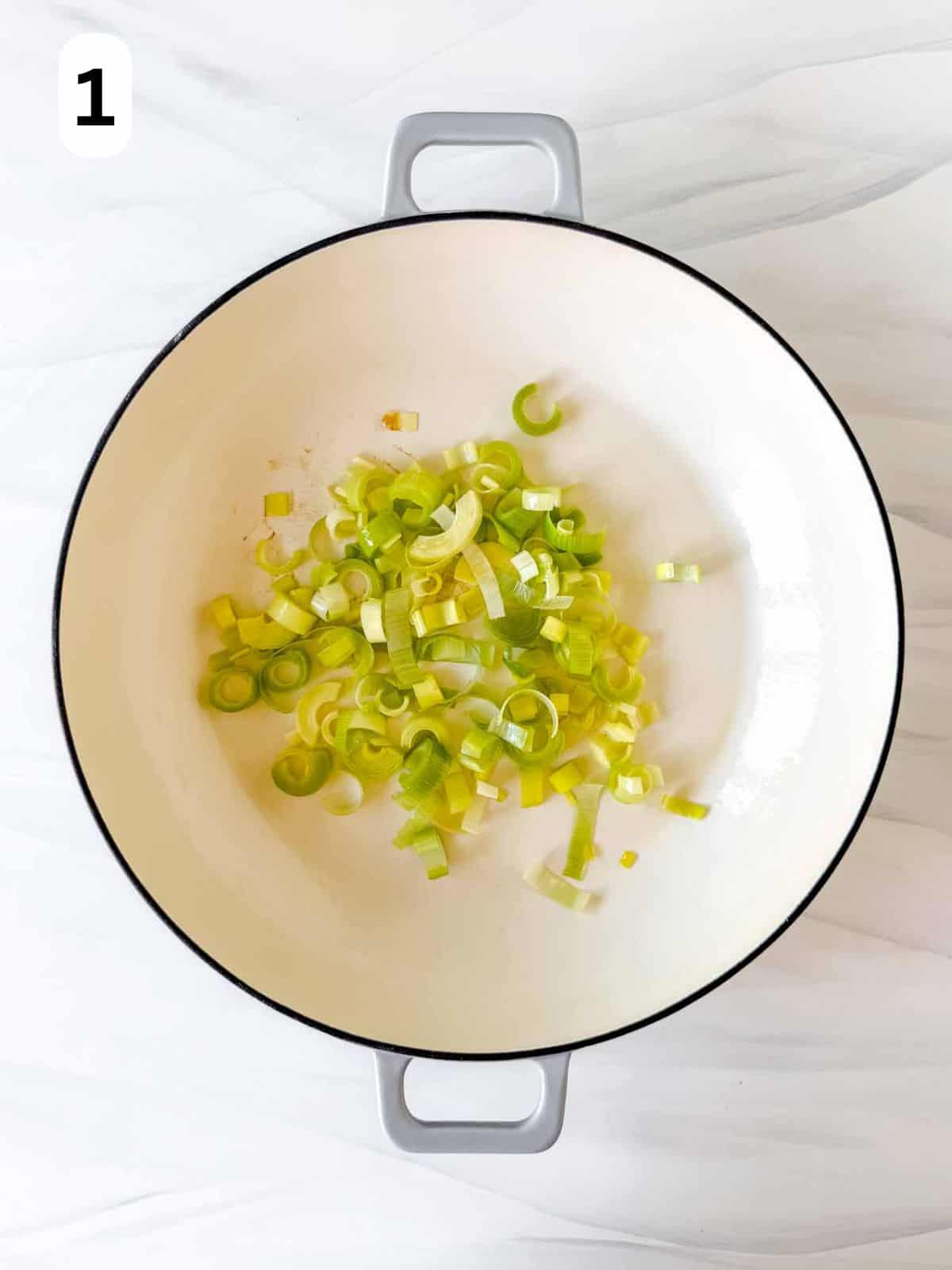 dice leeks in a Dutch oven labelled number one.