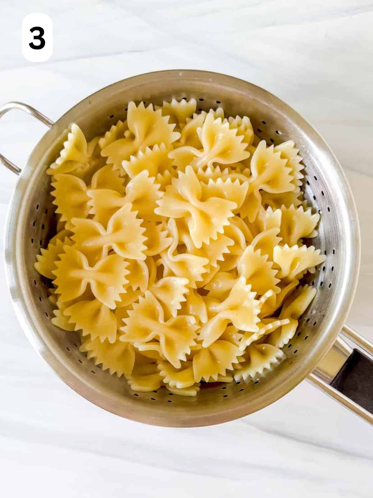 cooked pasta in a colander labelled number three.