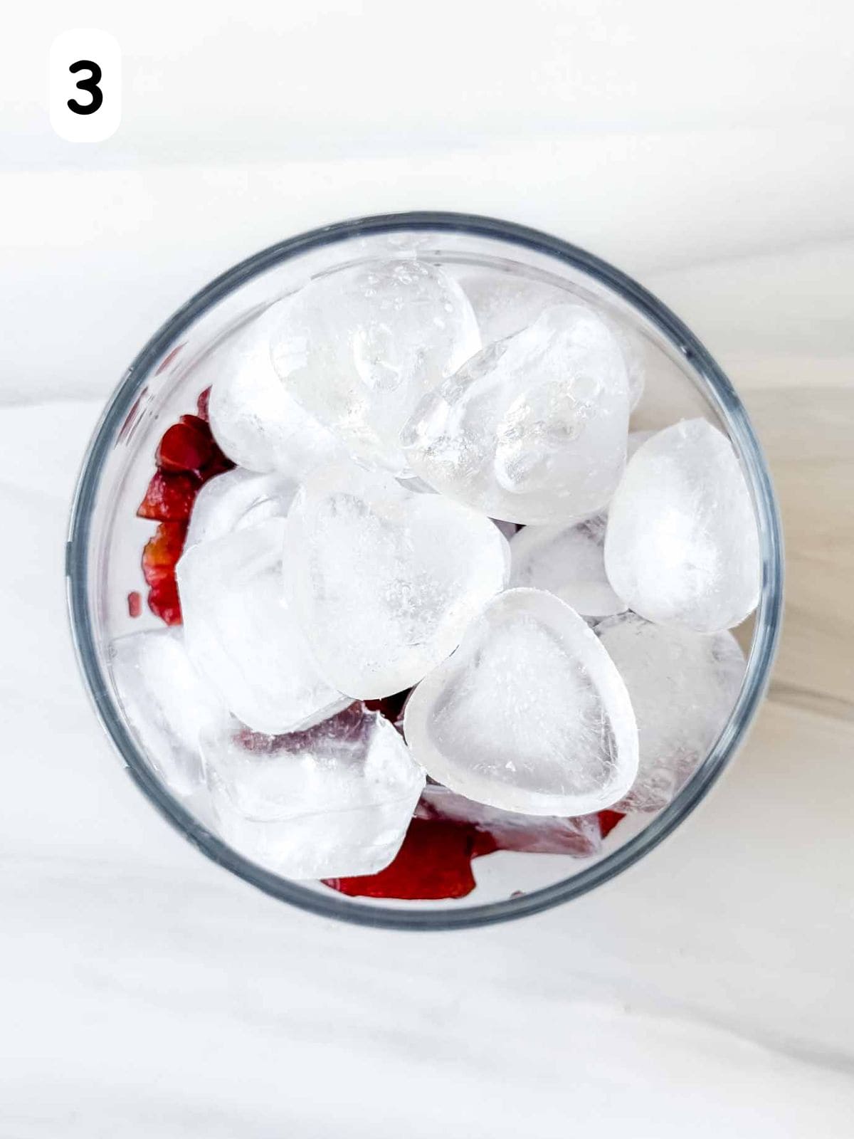 muddled cherries and ice cubes in a glass labelled number three.