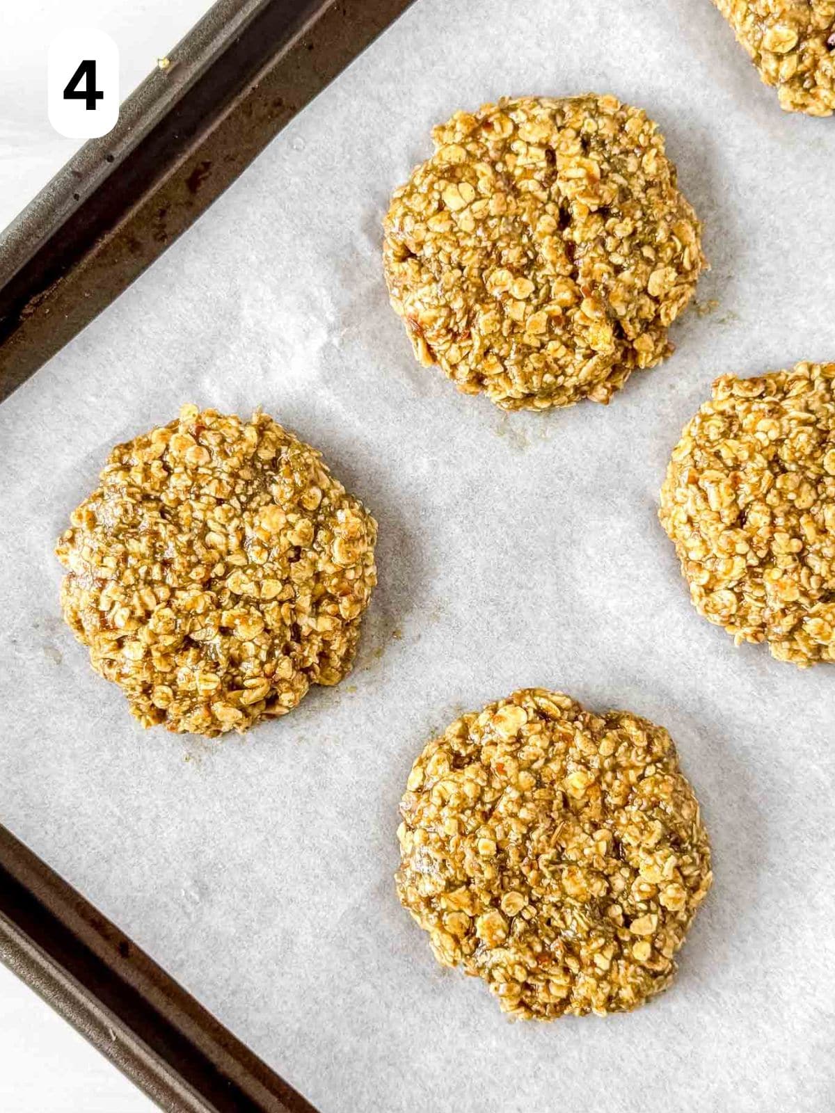 pumpkin seed butter cookies on a baking sheet lined with parchment paper labelled number four.
