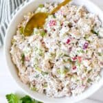 cottage cheese chicken salad in a white bowl next to parsley.