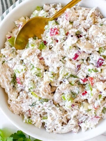 cottage cheese chicken salad in a white bowl next to parsley.
