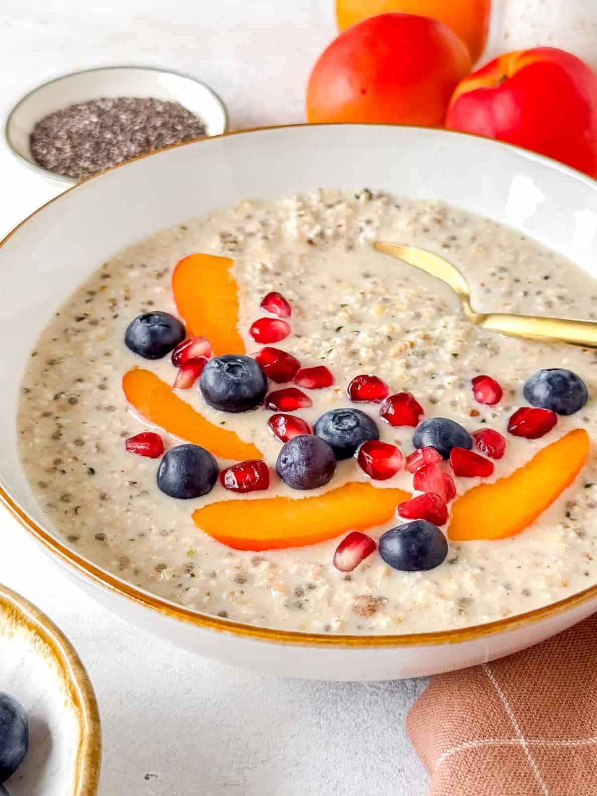 high protein overnight oats without protein powder in a white bowl topped with fruit.