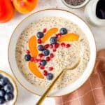 high protein overnight oats without protein powder in a white bowl topped with fruit.