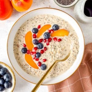 high protein overnight oats without protein powder in a white bowl topped with fruit.
