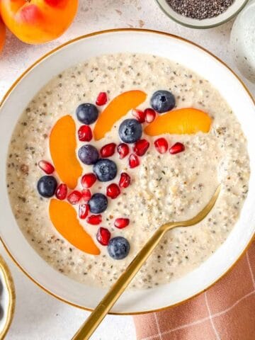 high protein overnight oats without protein powder in a white bowl topped with fruit.