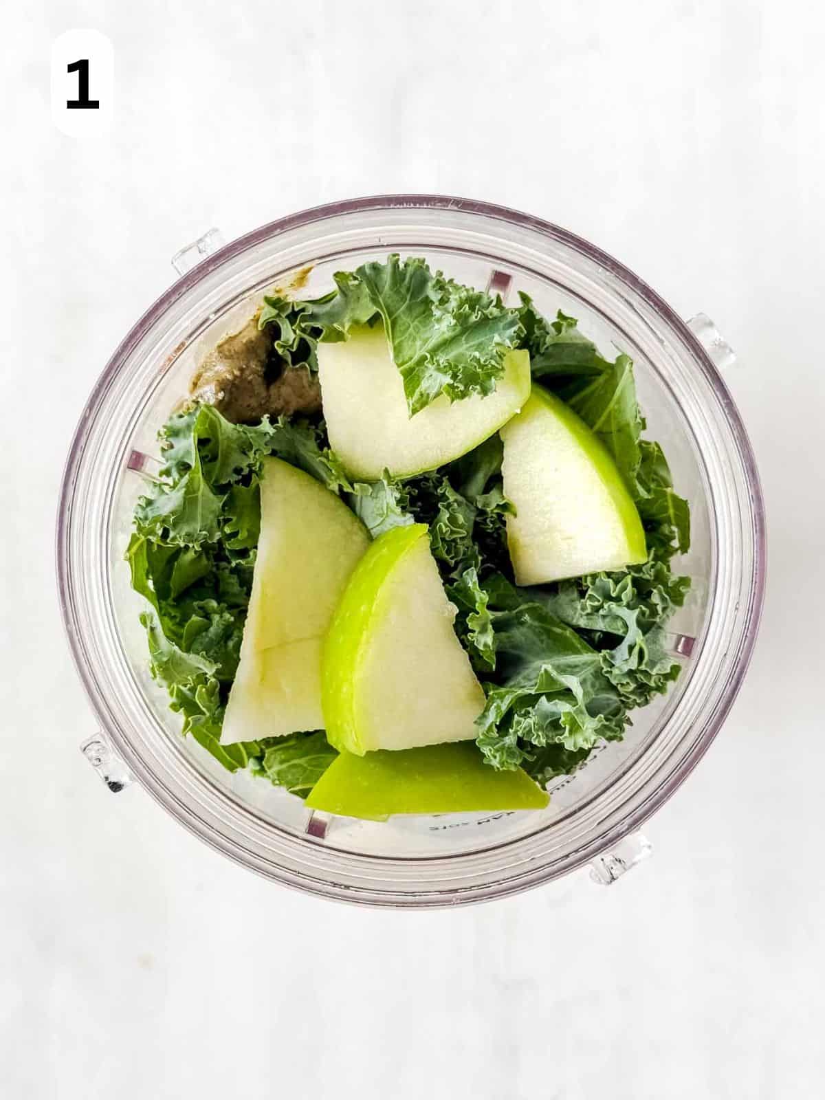 kale, sliced apple and pumpkin seed butter in a blender cup labelled number one.