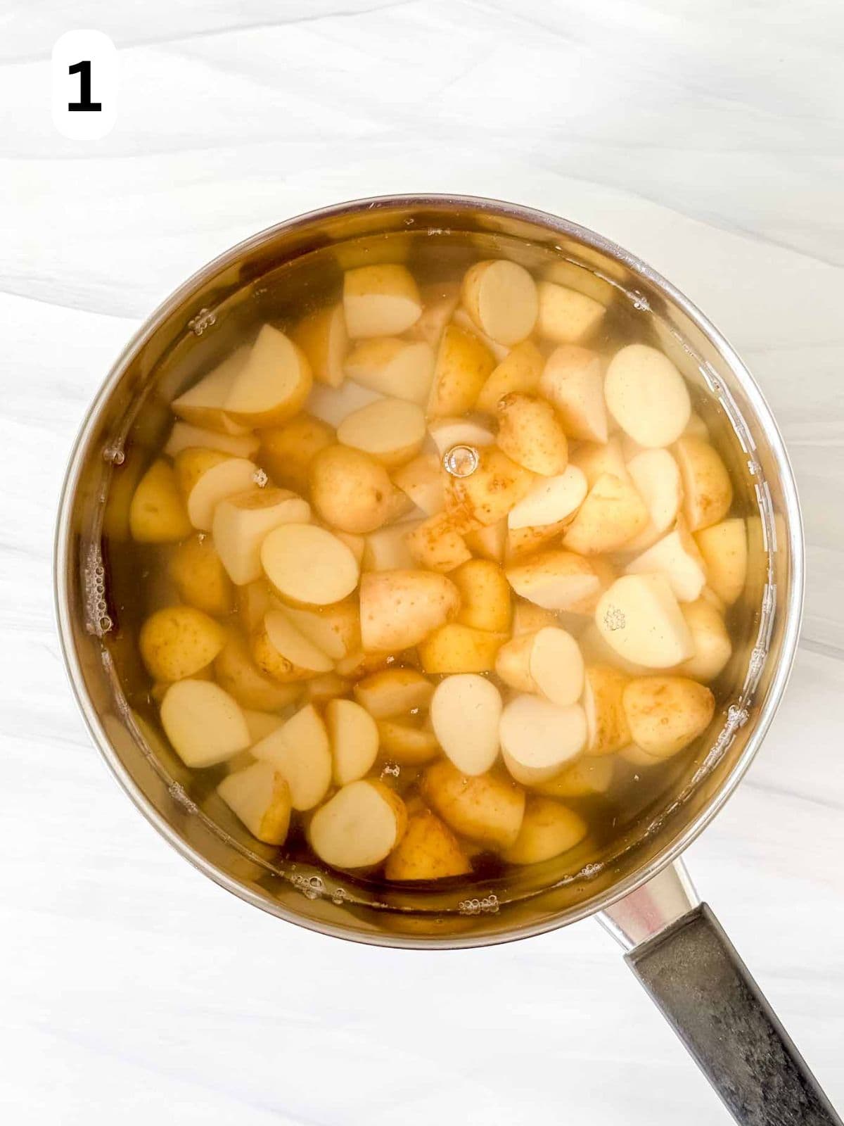 cooked new potatoes in water in a pot labelled number one.